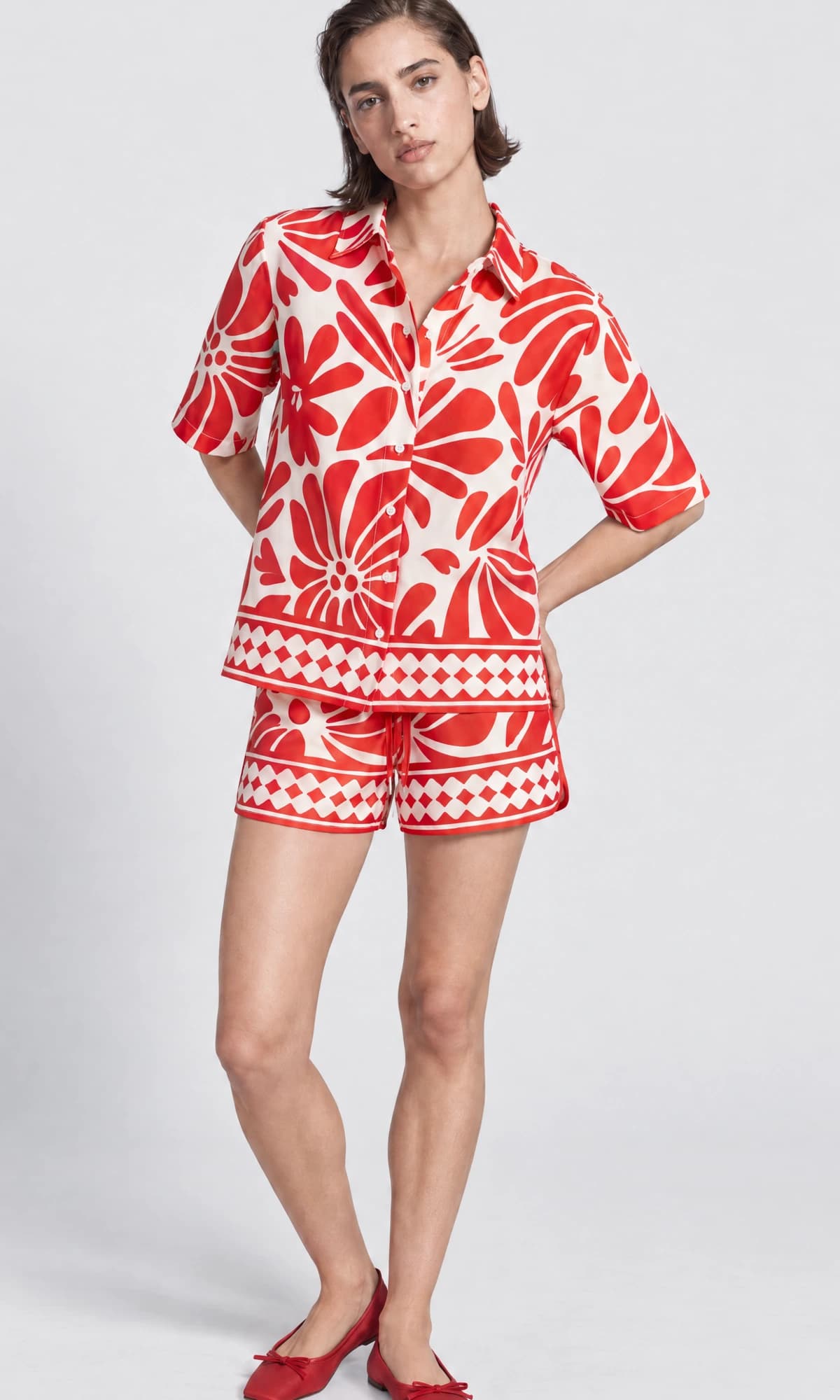 Standing catalogue view of a model wearing a red and white print set