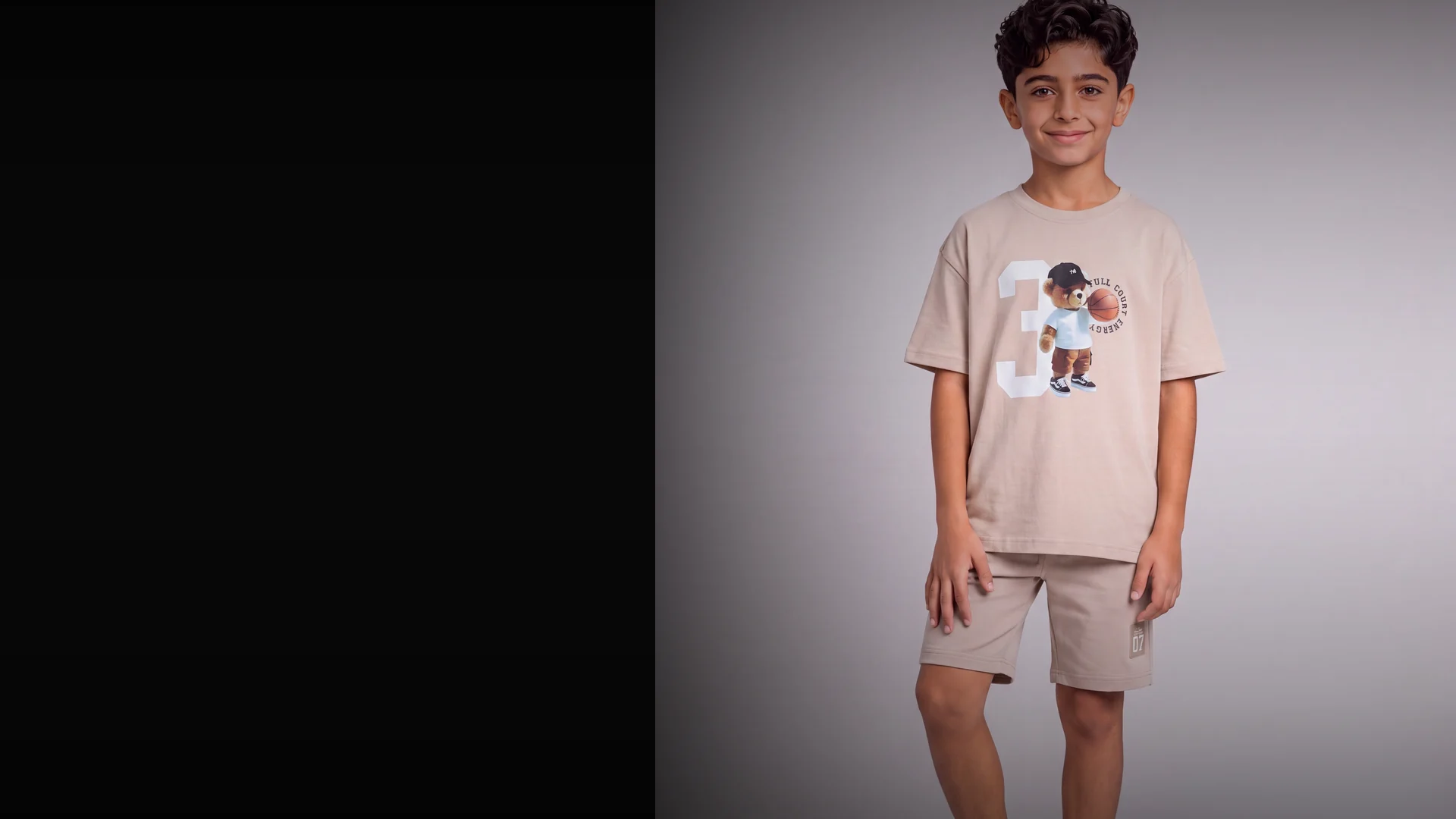 Child fashion model positioned beside a dark copy field for catalogue production.